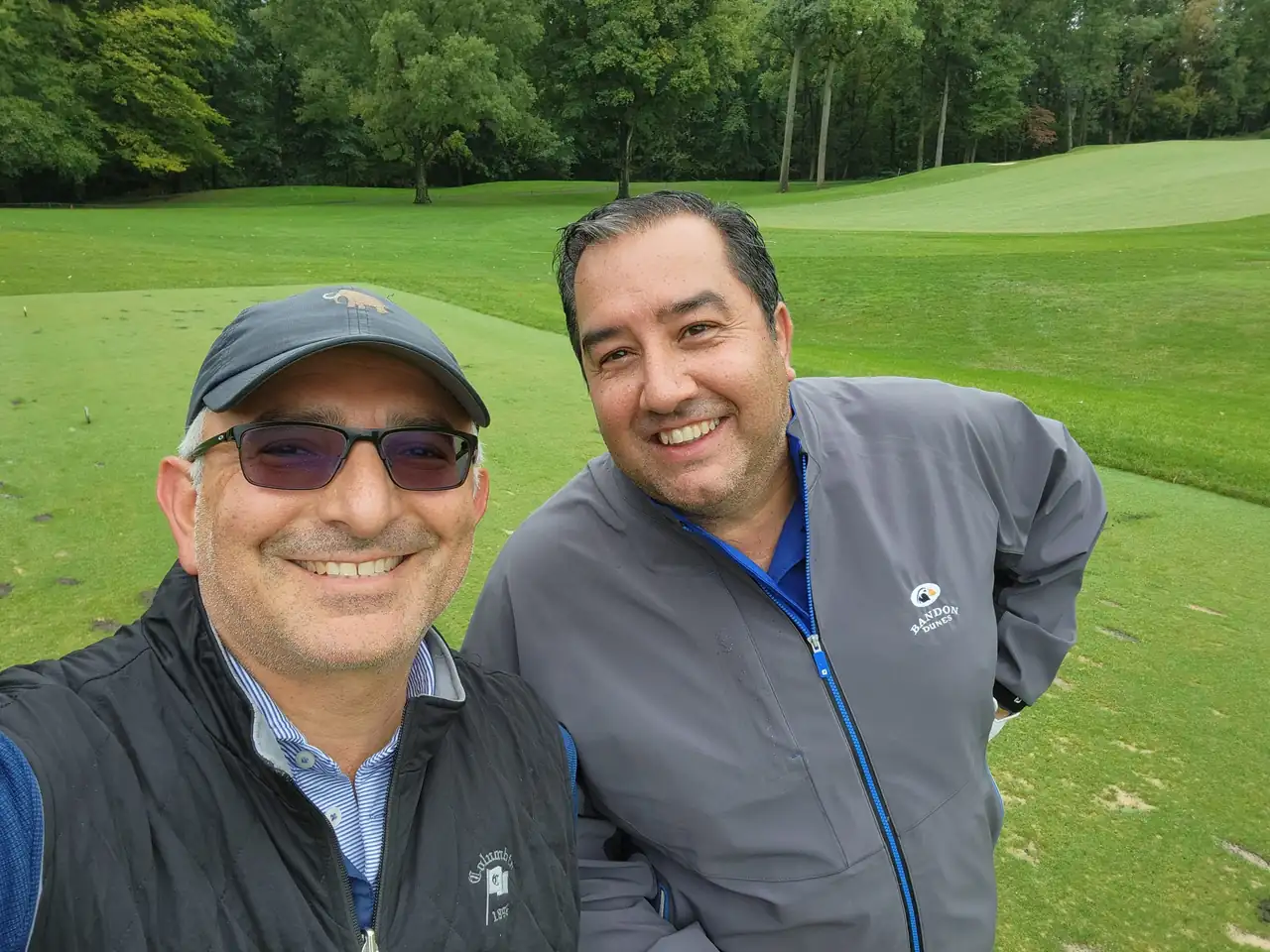 Two of the group in rain jackets on a Columbia Country Club fairway