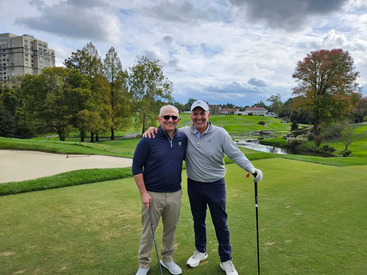 The Perry Bros by a bunker and creek at Columbia Country Club in October